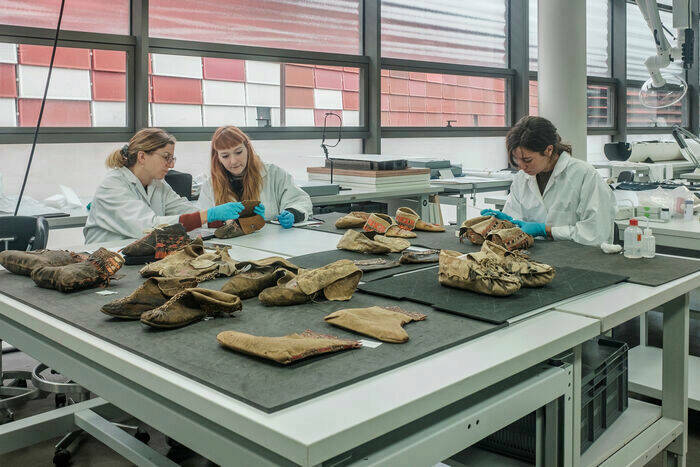  French conservators Camille Alembik, Diane Messager and Mélanie Pichaud during the conservation treatment of a selection of moccasins in the conservation lab, November 2022